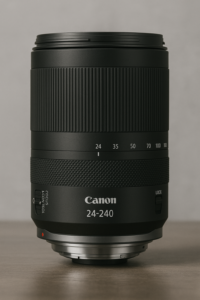 Canon RF 24-240mm f/4-6.3 IS USM Zoomobjektiv in aufrechter Position, fotografiert auf einem Holztisch vor neutralem Hintergrund