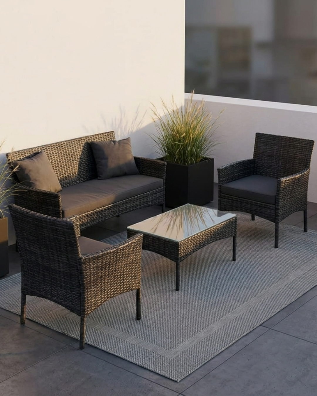 Polyrattan Lounge Set anthrazit mit Sofa, Sesseln und Tisch auf modernem Stadtbalkon