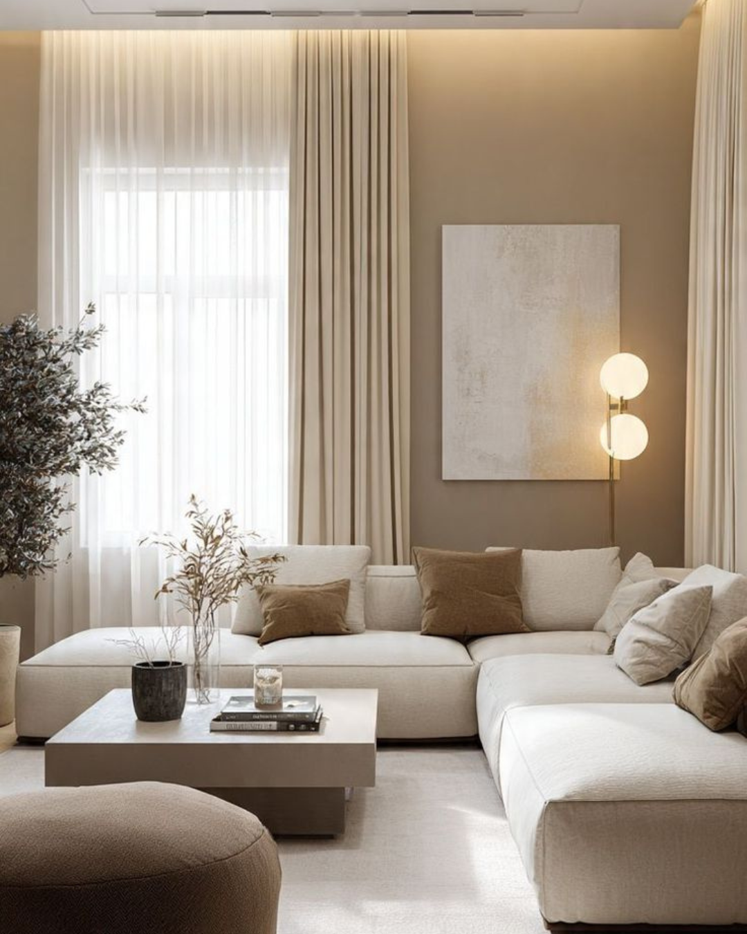 Minimalistisches Wohnzimmer mit beigefarbenem Sofa und Deko